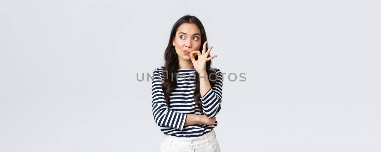 Lifestyle, beauty and fashion, people emotions concept. Serious-looking worried asian woman thinking better keep mouth shut, looking away alarmed and zipping mouth to stay quiet by Benzoix