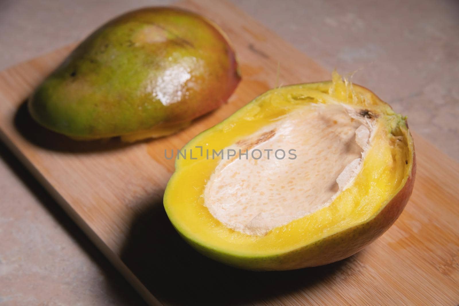 Close-up shallow depth of field cutaway mango kent on a cutting board. Mango home cooking.