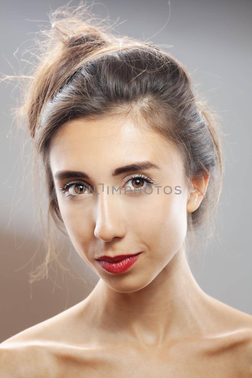 Beautiful brunette girl studio portrait. Smiling face expression.