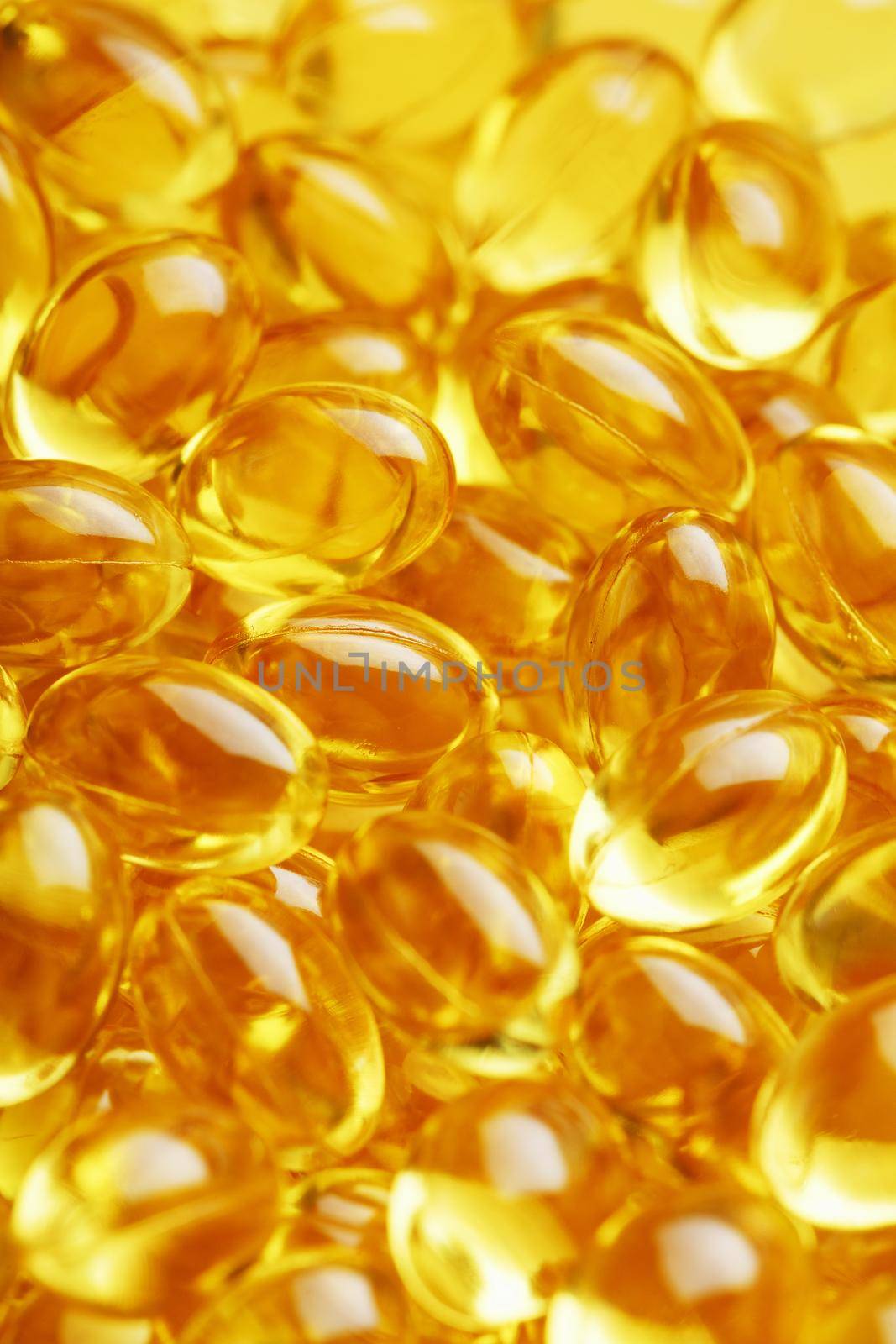 Golden Vitamin D3 Capsules close-up in full screen by AlexGrec