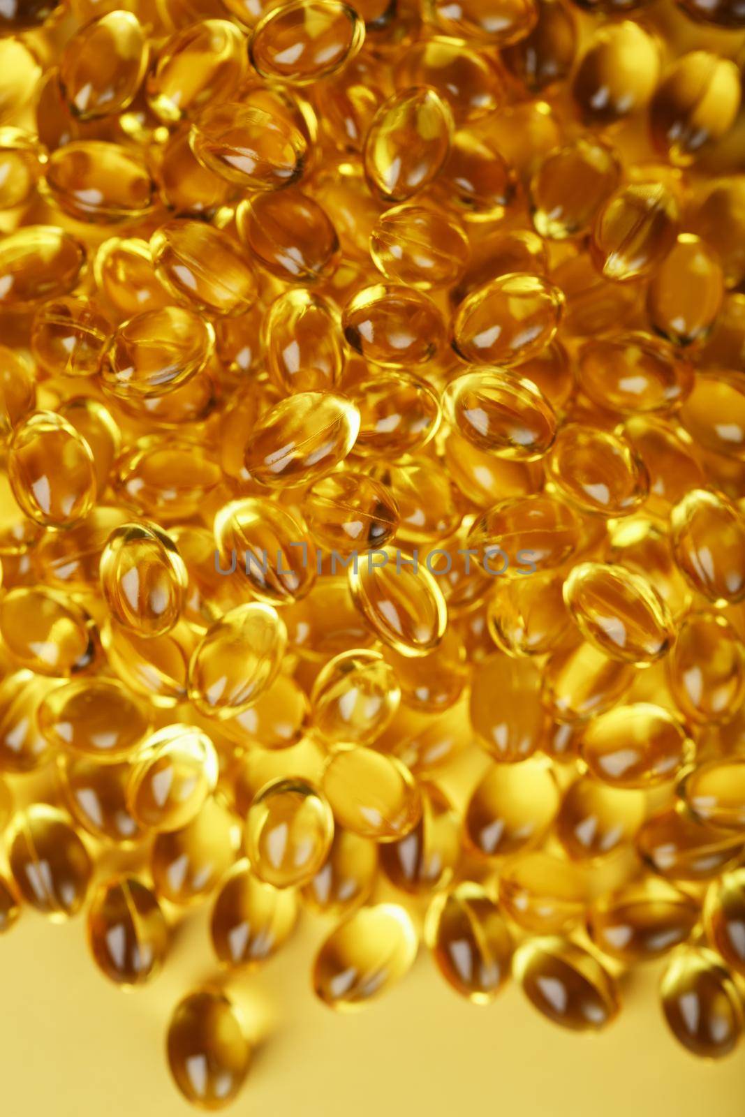 Golden capsules of Vitamin Omega 3 Fish Oil close-up by AlexGrec