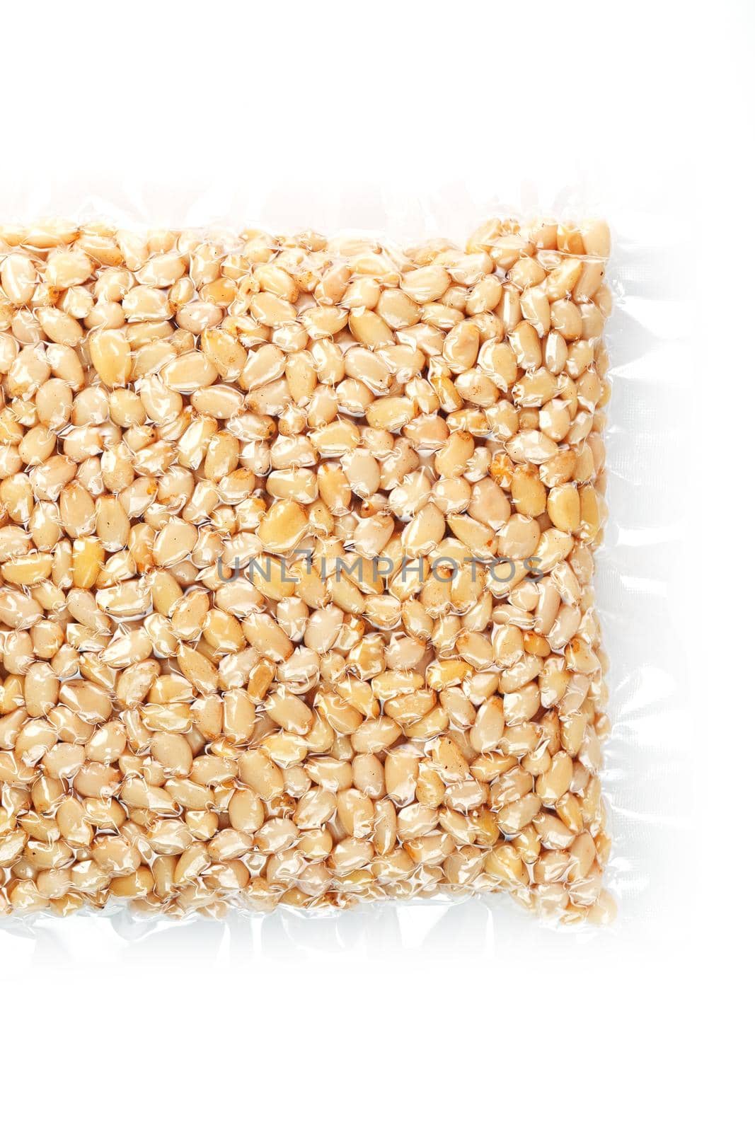 Kernels of peeled pine nuts in vacuum packaging on a white background by AlexGrec