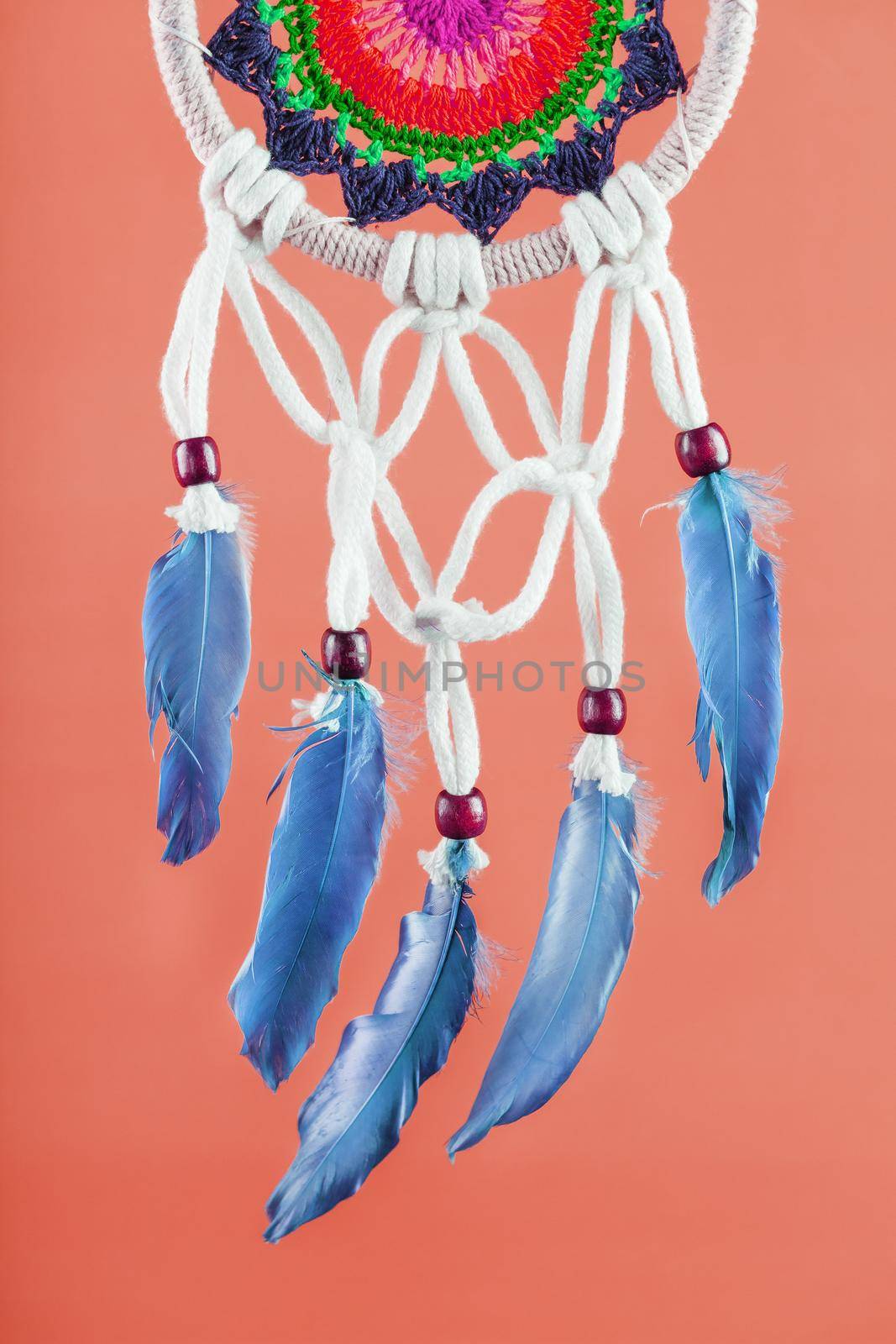 Amulet Dreamcatcher on a red background close-up protecting the sleeper from evil spirits and diseases