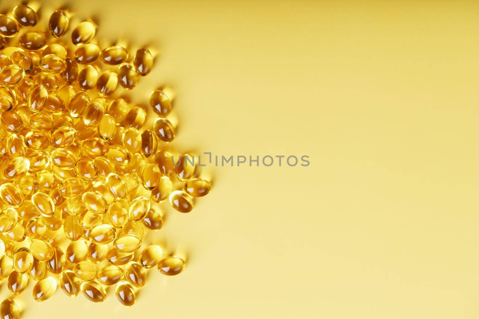 The texture of the capsules in the shell with liquid vitamin D3 in full screen. Gold capsules with a dietary supplement for joints teeth and bones.