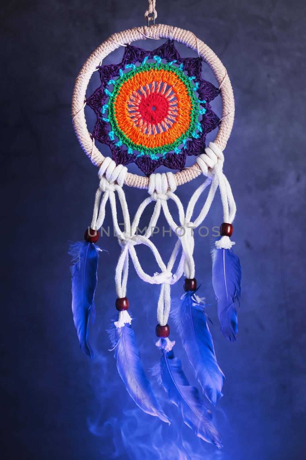 Dream catcher on a dark background with smoke and aquamarine light. Isolate