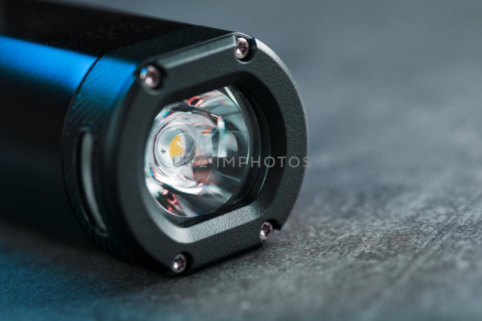 Black Rechargeable Flashlight handheld, LED close-up on a black background