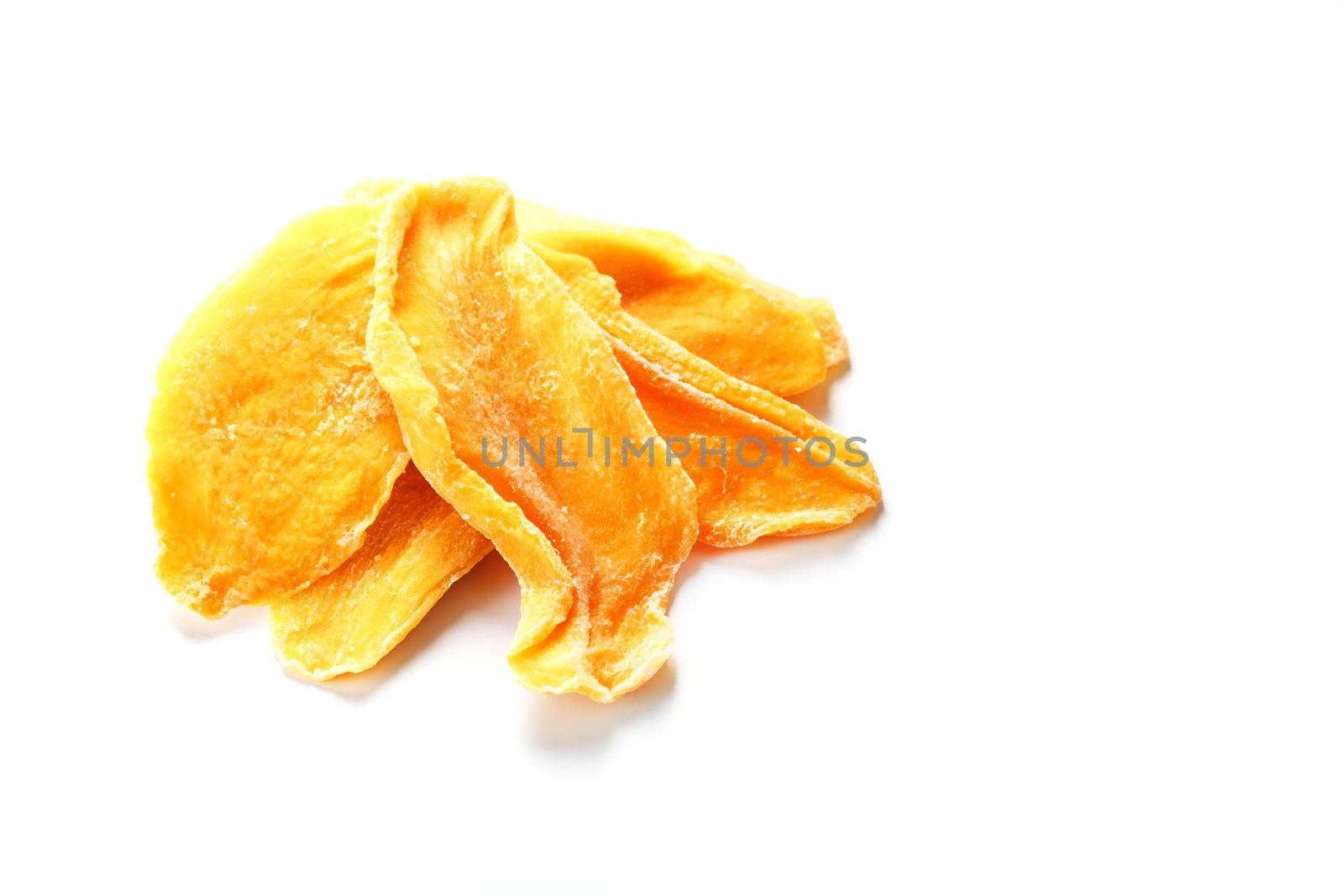 Dried sweet mango fruit slices as textural orange background in full screen