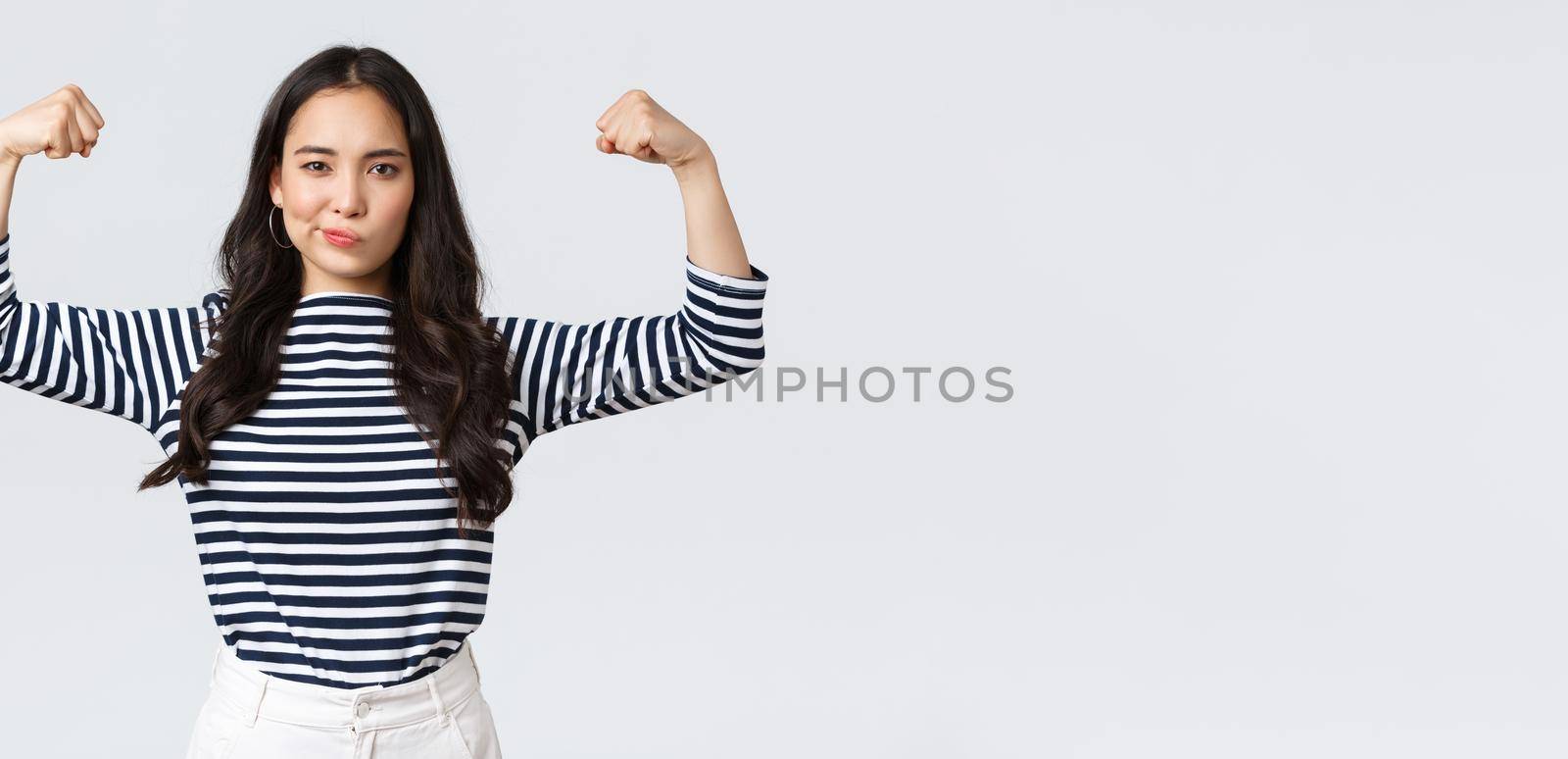 Lifestyle, people emotions and casual concept. Strong and confident asian woman flex biceps, bragging her perfect shape after sign-up gym membership, brag with muscles, workout and feeling strong by Benzoix