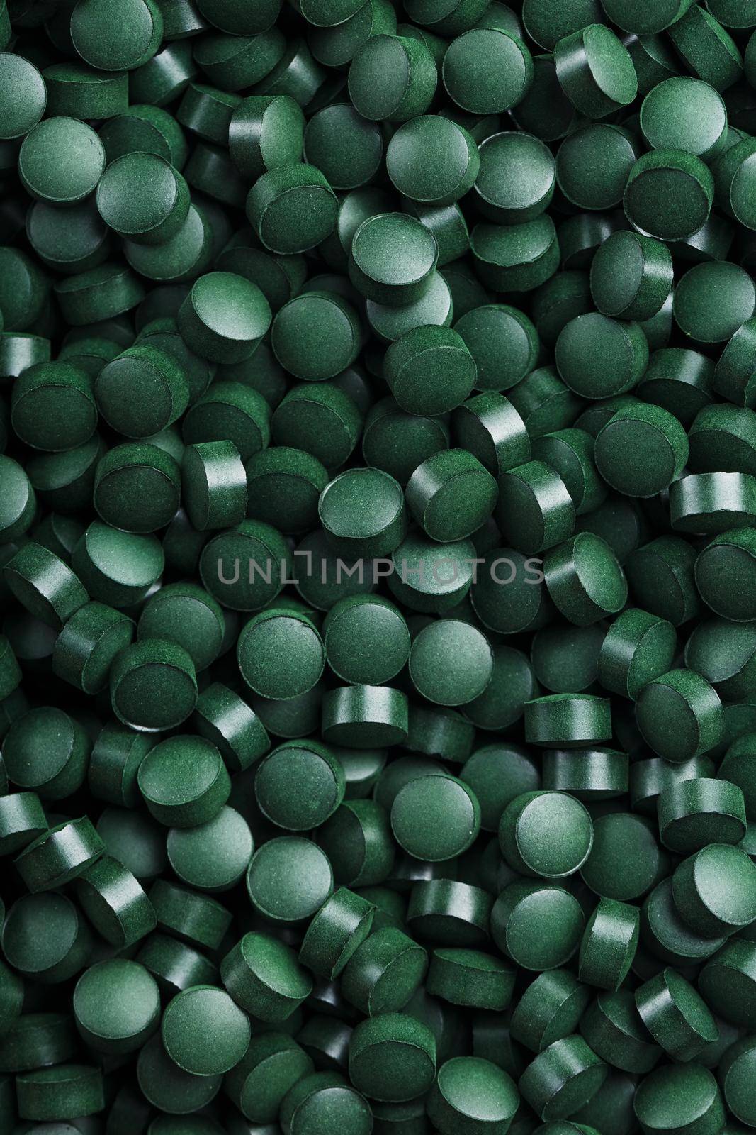 Green tablets from spirulina vegetarian dietary supplement as a full-screen texture