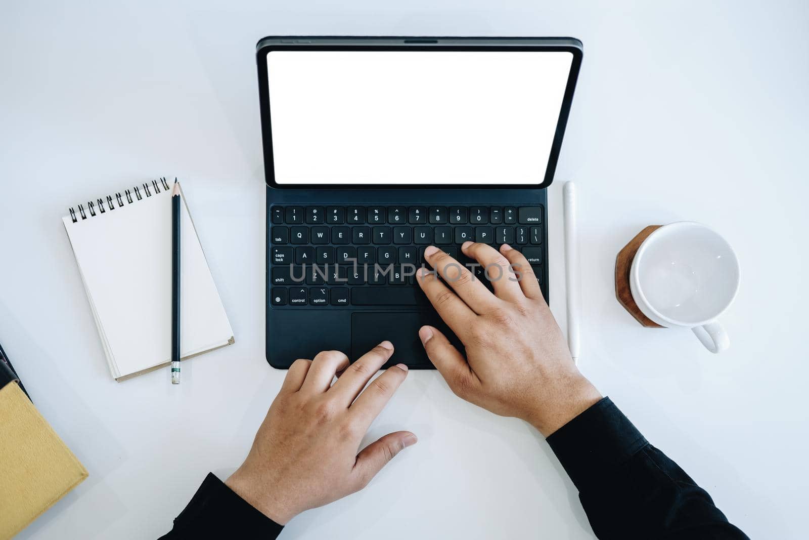 Young man using work from home tablet at work, the blank space on the computer screen can insert text