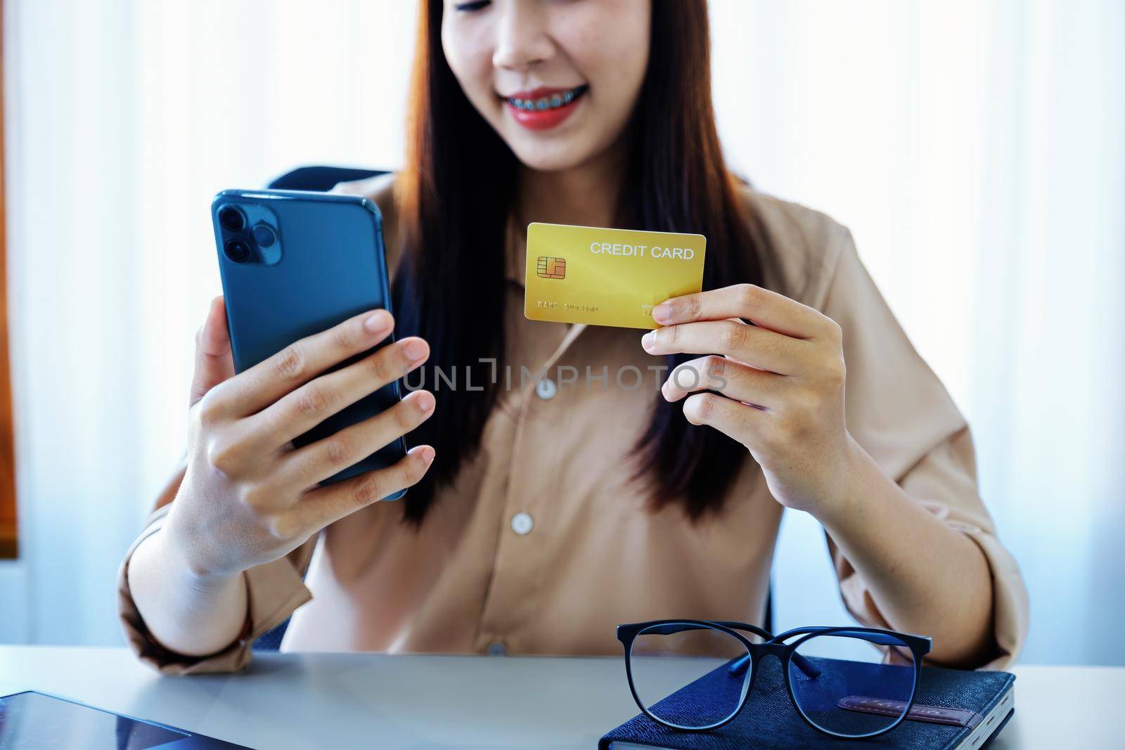 Online Shopping and Internet Payments, Beautiful Asian women are using their credit cards and mobile phones to shop online or conduct errands in the digital world. by Manastrong