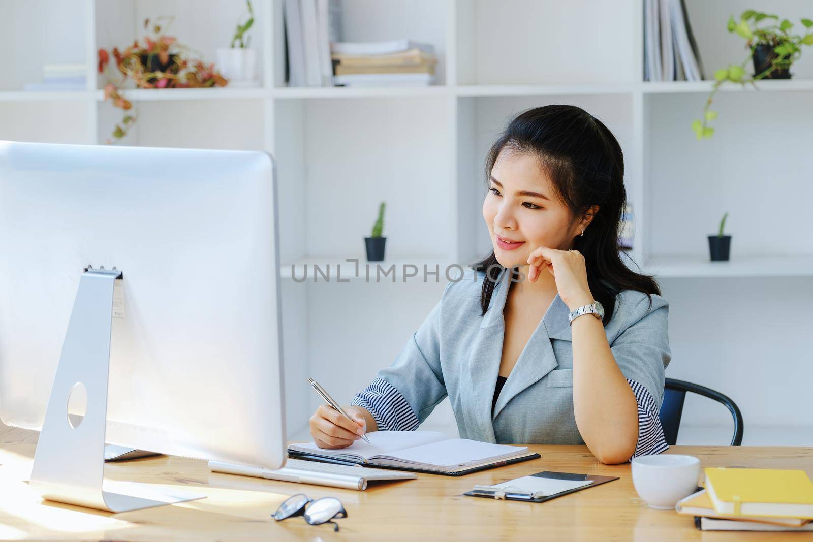 Young economists or accountants or financiers and investors are reviewing budget documents and using computers to study impact and risk assessments on corporate investment management. by Manastrong