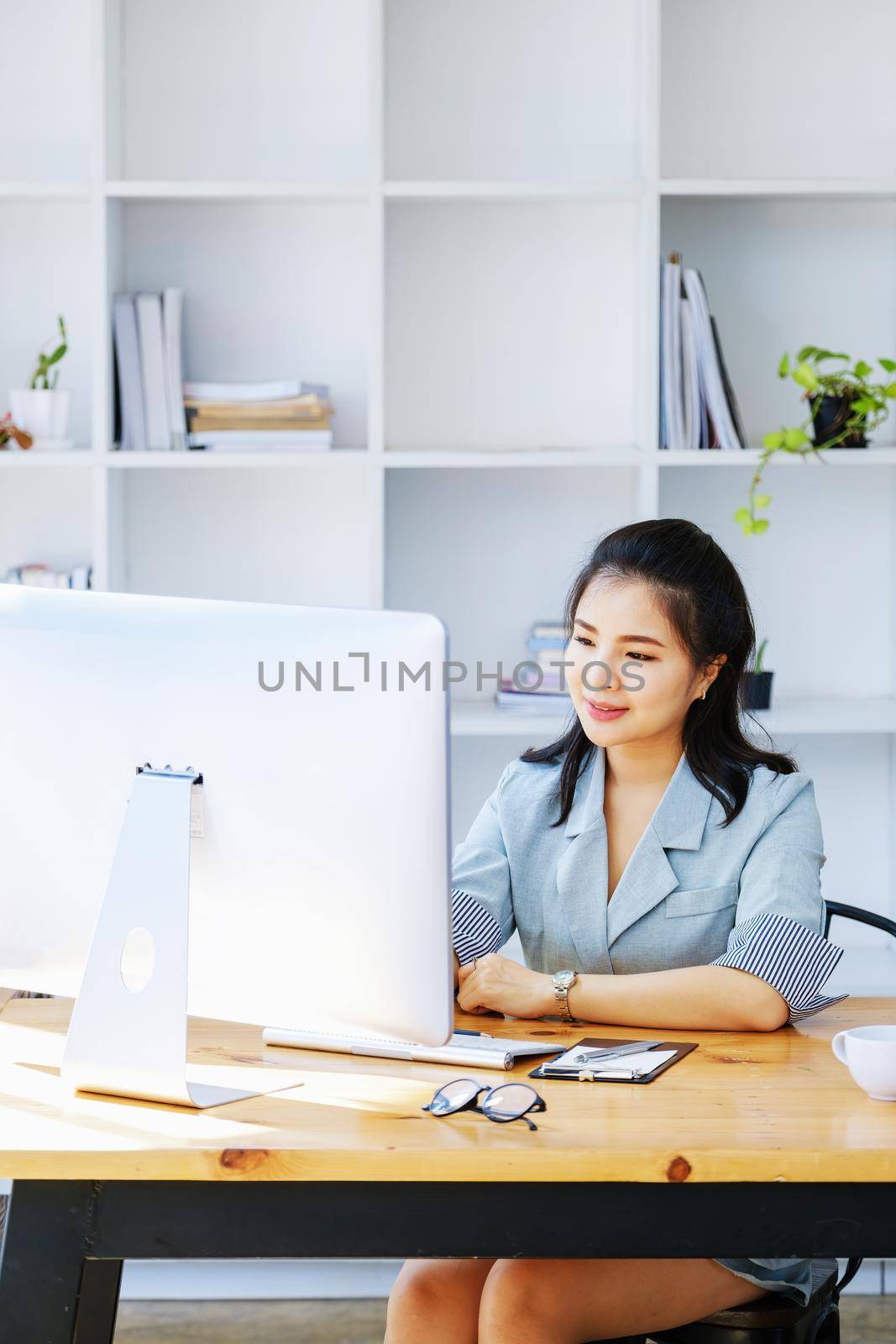 Young economists or accountants or financiers and investors are reviewing budget documents and using computers to study impact and risk assessments on corporate investment management