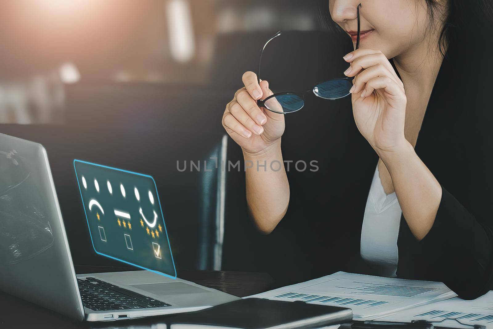 Quality and Satisfaction Rating Concept, Assessment, smiling businesswoman using laptop computer to answer surveys and assess 5-star satisfaction