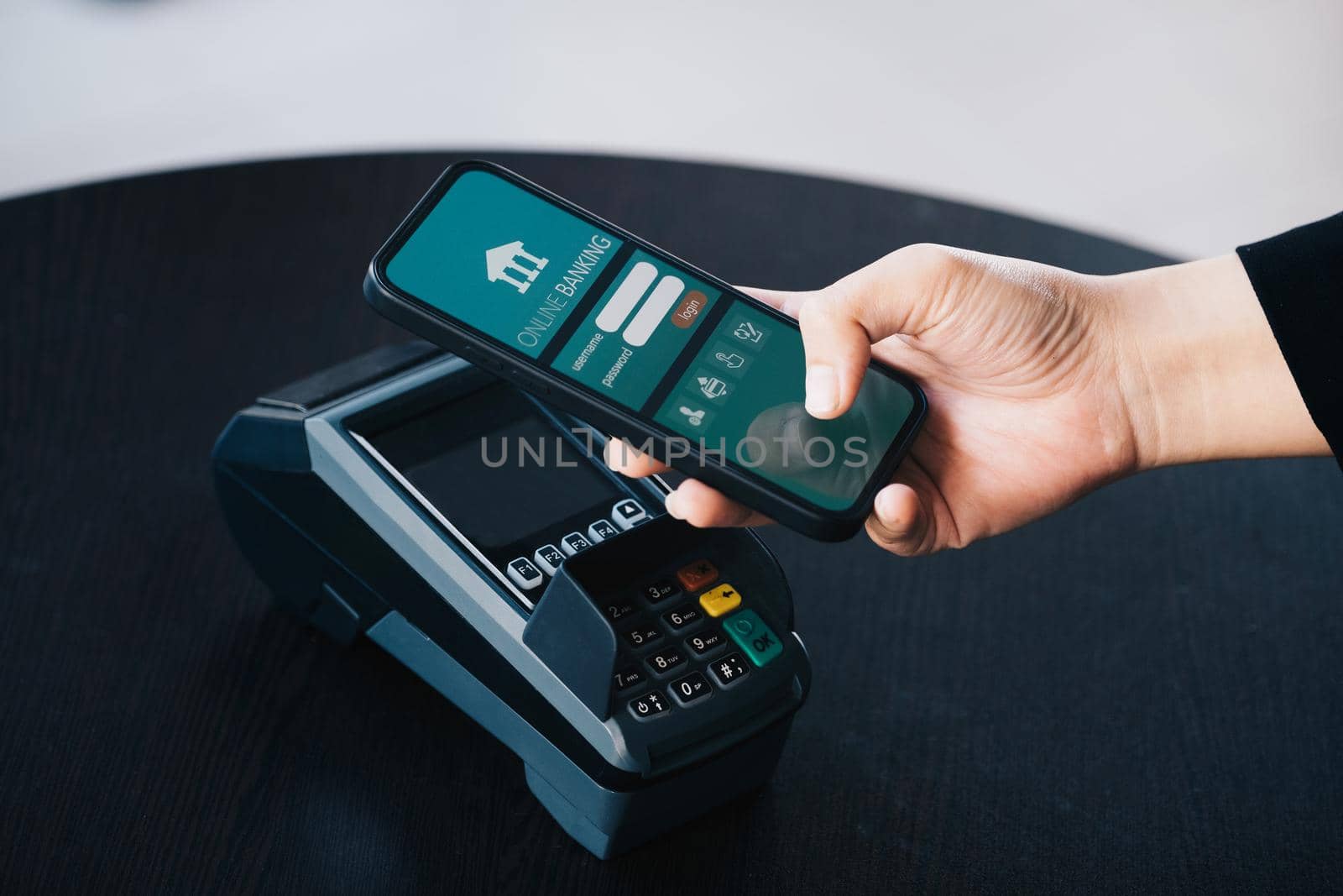 Secure payment technology concept and service charge, customers are using their phone to pay using paywave technology by tapping near the electronic card terminal. by Manastrong