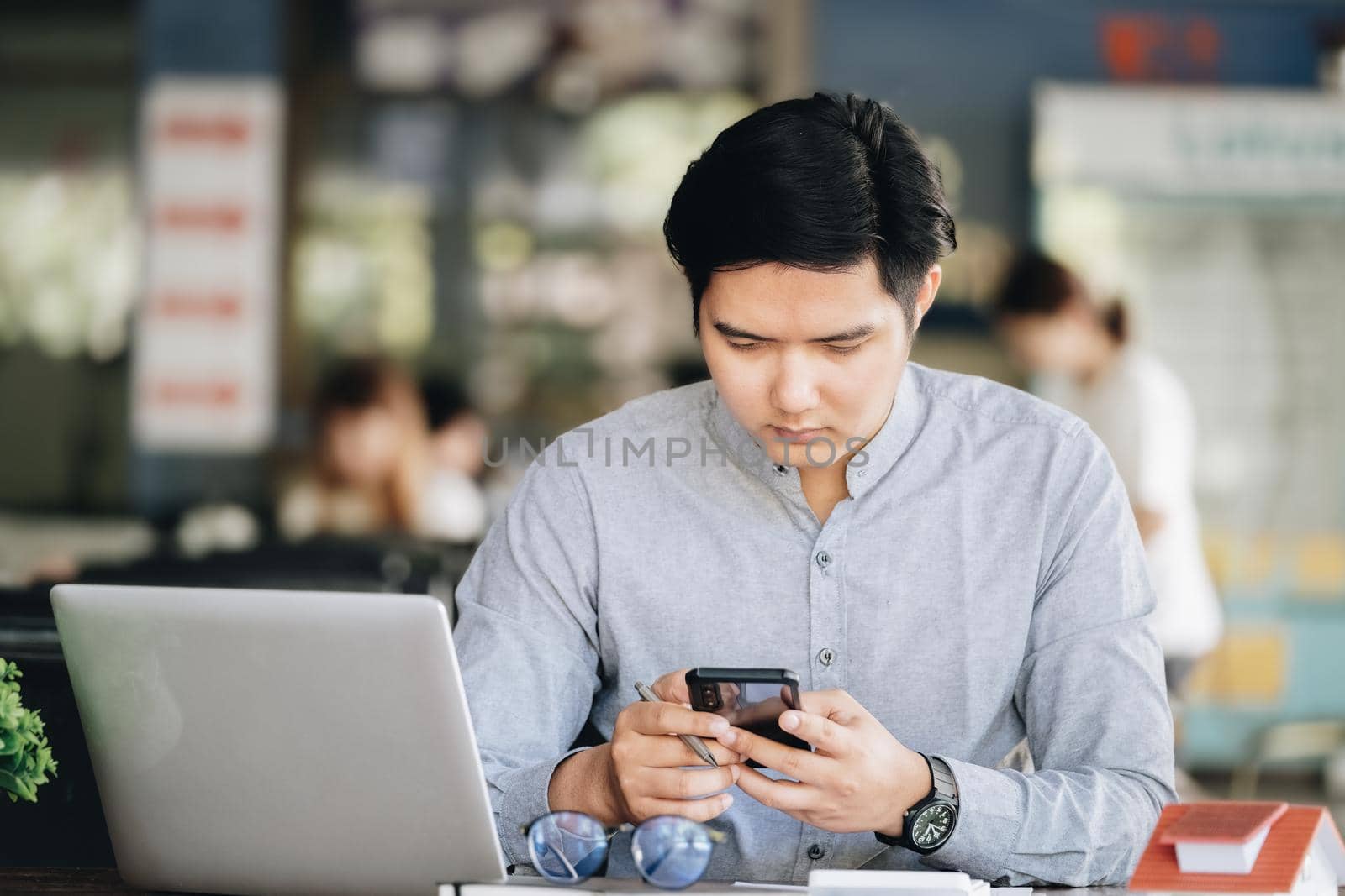 A male businessman is using the telephone to communicate with colleagues for financial planning and investment planning. by Manastrong