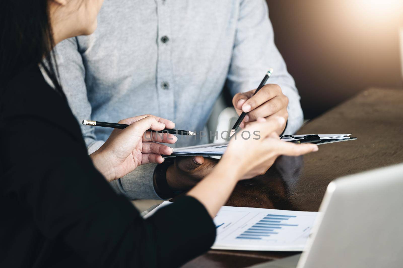 Teamwork concept, consultation, female advisor pointing to budget, finance and investment papers, discussing and planning finances with male economists in conference room. by Manastrong