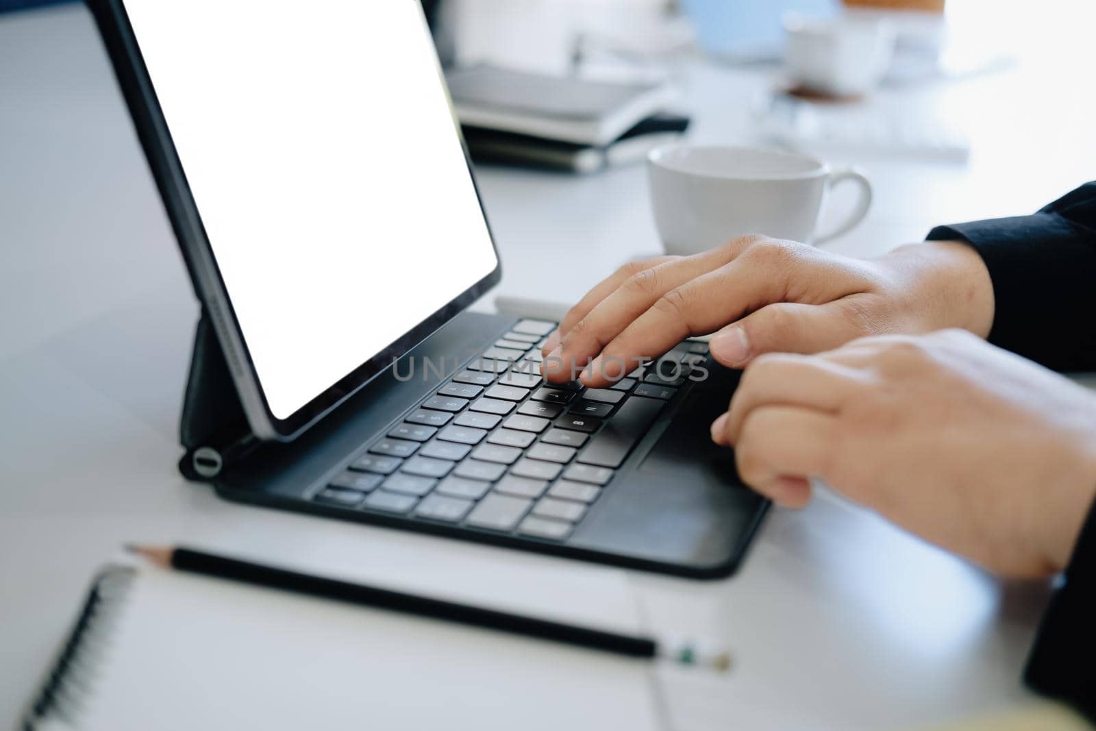 Young man using work from home tablet at work, the blank space on the computer screen can insert text. by Manastrong