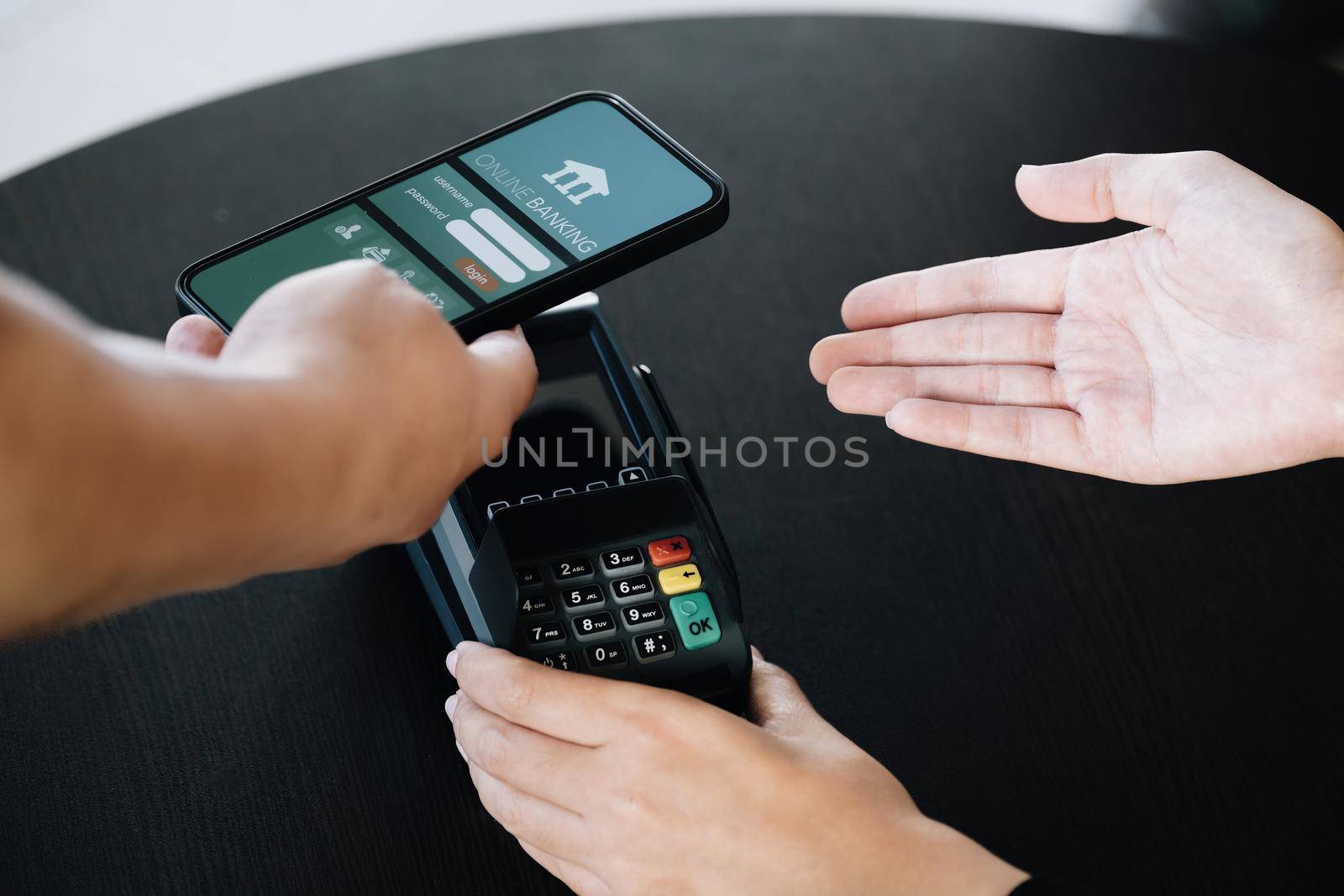 Payment security technology concept and service fees, Employees are holding electronic card machines for customers to use smartphone mobile to pay via paywave technology. by Manastrong