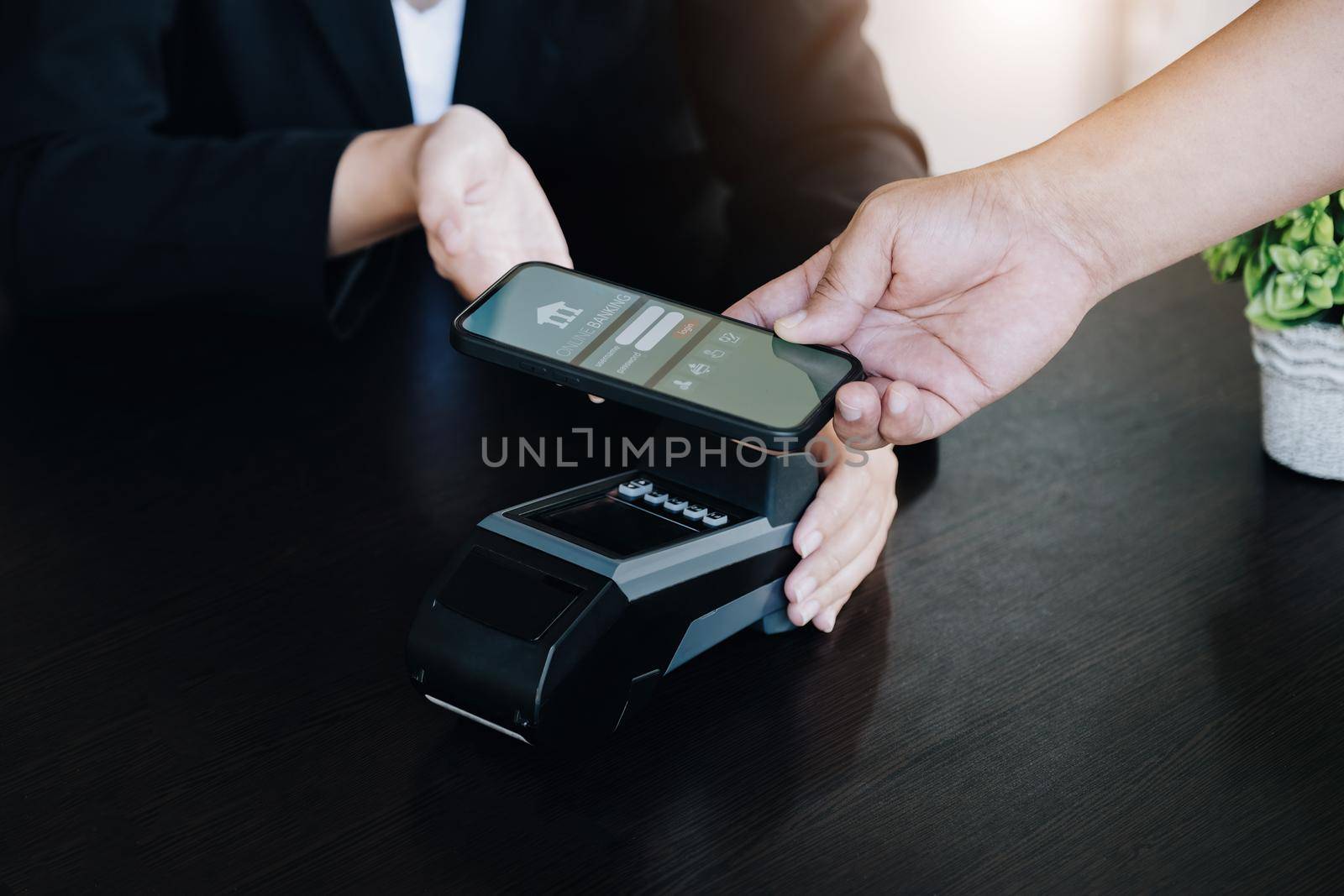 Payment security technology concept and service fees, Employees are holding electronic card machines for customers to use smartphone mobile to pay via paywave technology