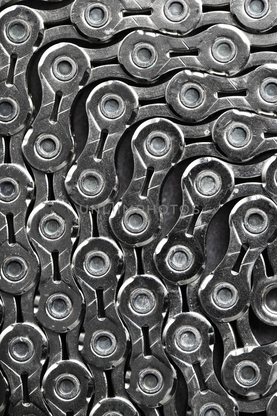 The texture of a bicycle chain is a close-up of the torque transmission links by AlexGrec