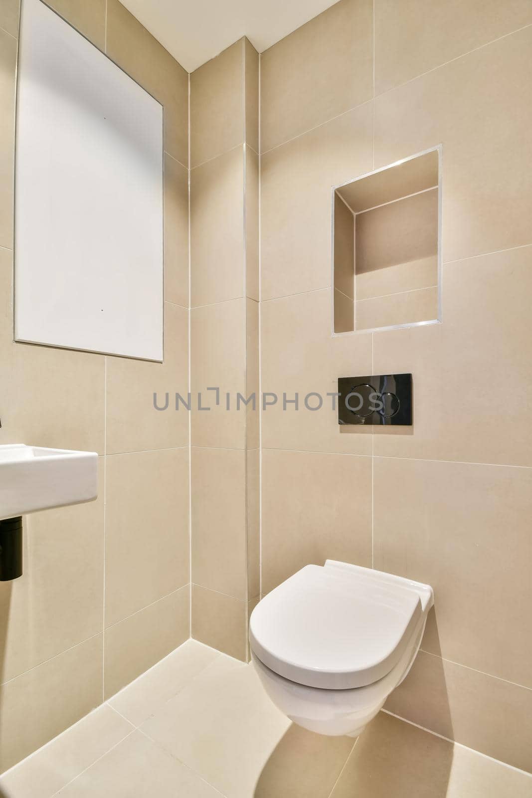 Modern toilet with a small sink in the corner lined with beige tiles