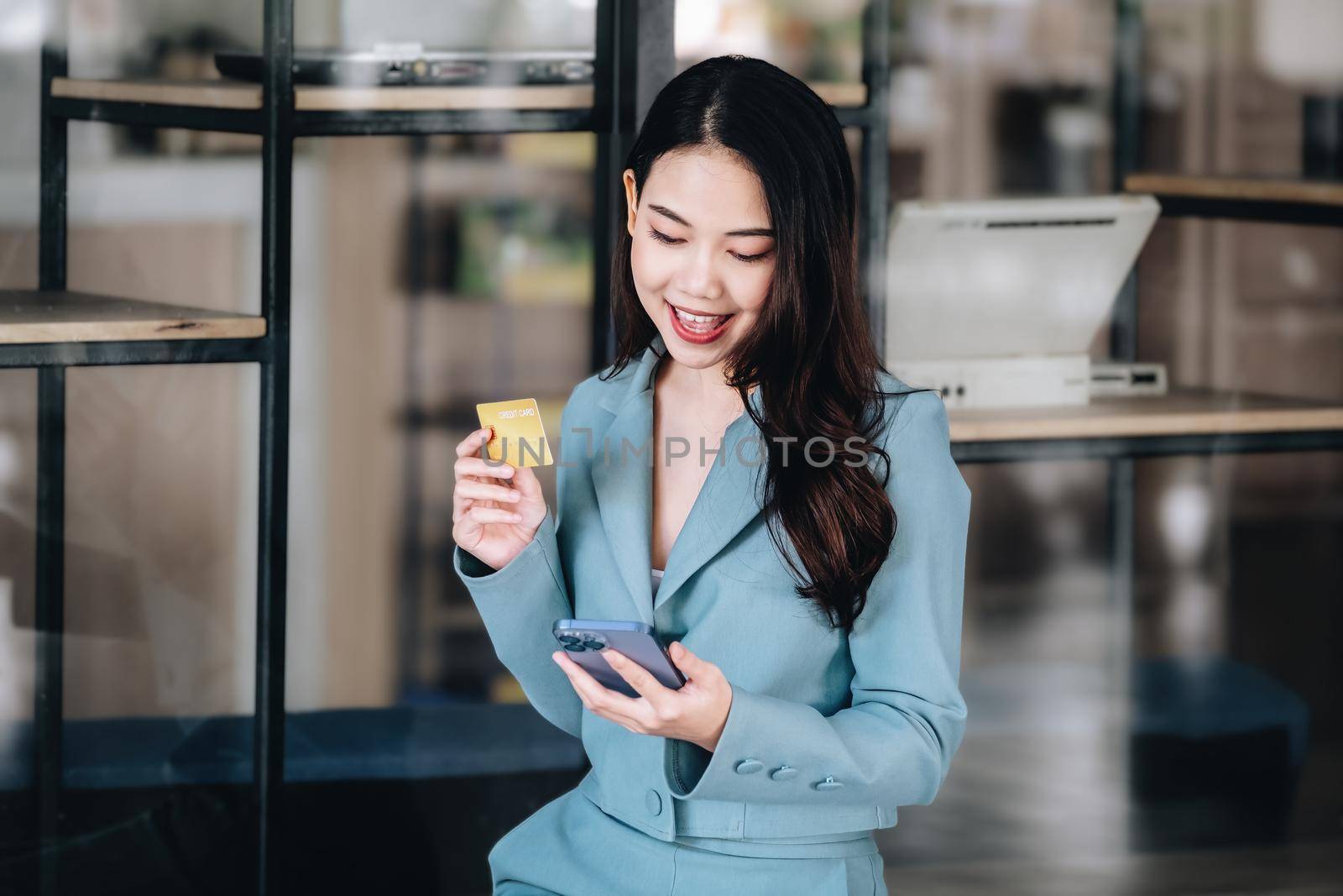 Online Shopping and Internet Payments, Beautiful Asian women are using their credit cards and mobile phones to shop online or conduct errands in the digital world. by Manastrong