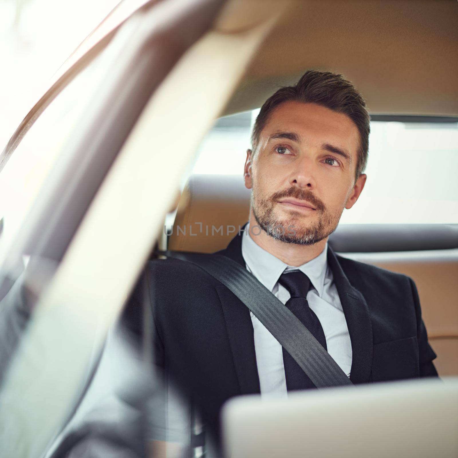 Cropped shot of a businessman in the backseat of a car.