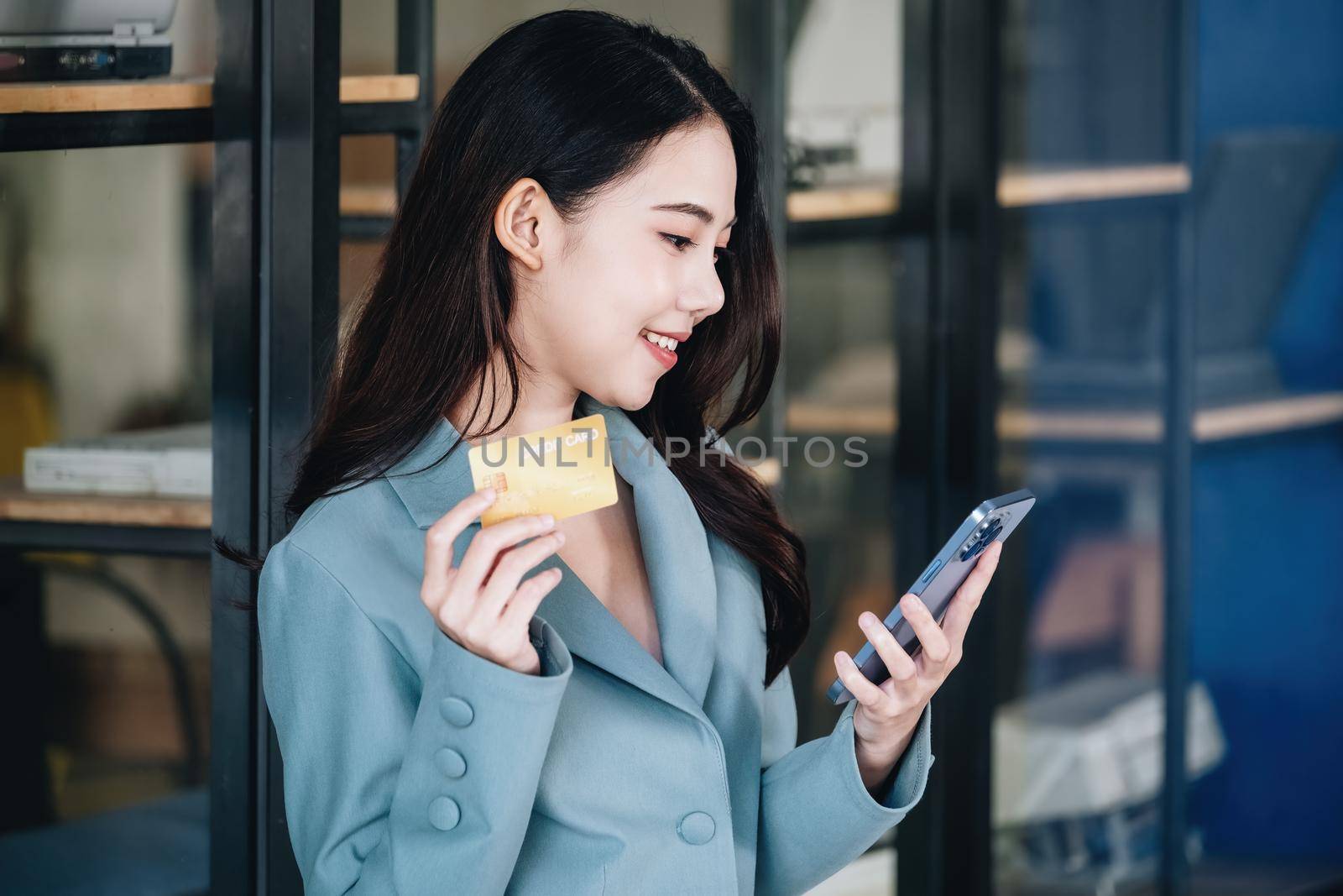 Online Shopping and Internet Payments, Beautiful Asian women are using their mobile phones and credit cards to shop online or conduct errands in the digital world. by Manastrong