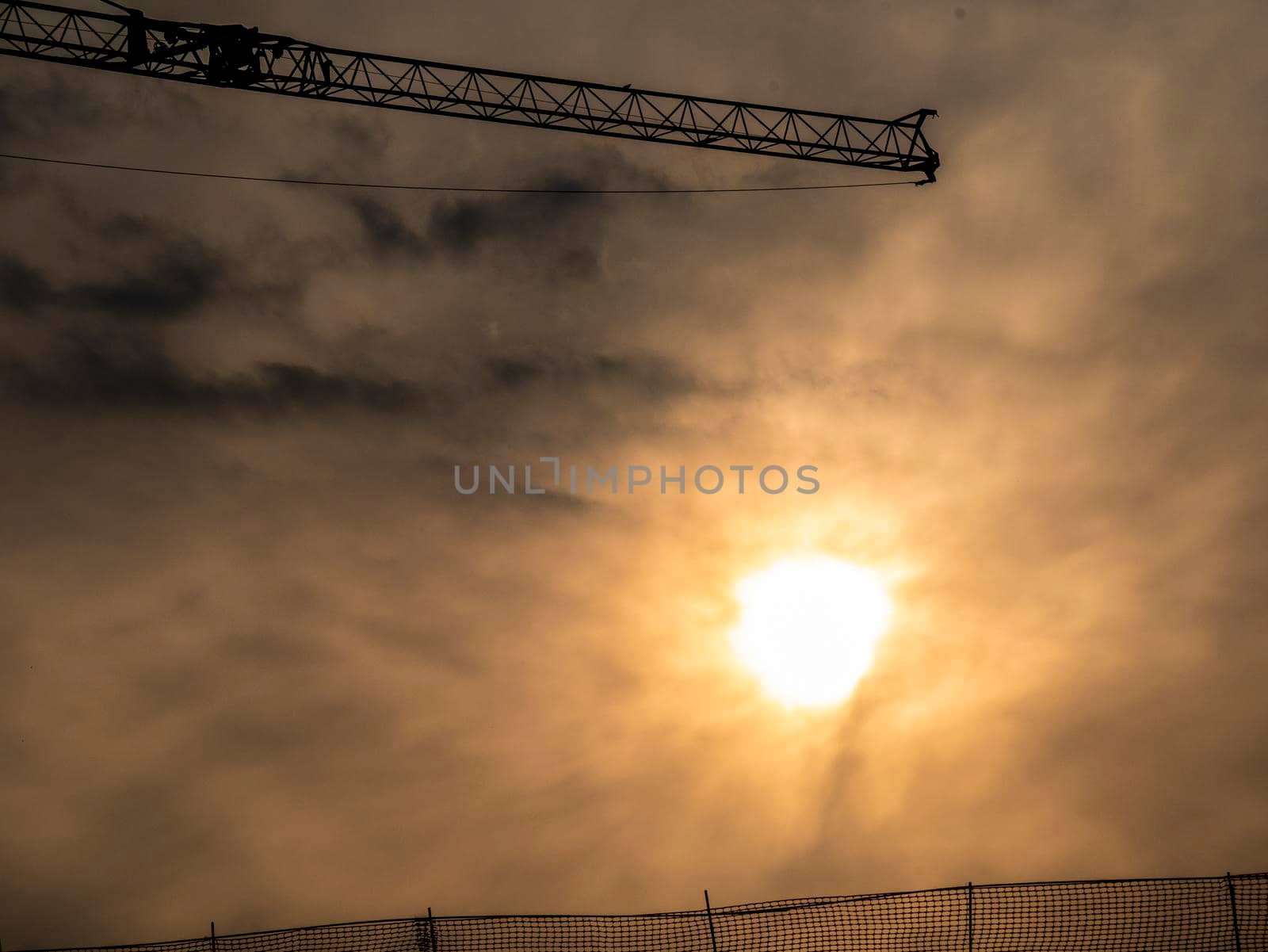 silhouette of a construction crane behind a sunset vintage style by lempro