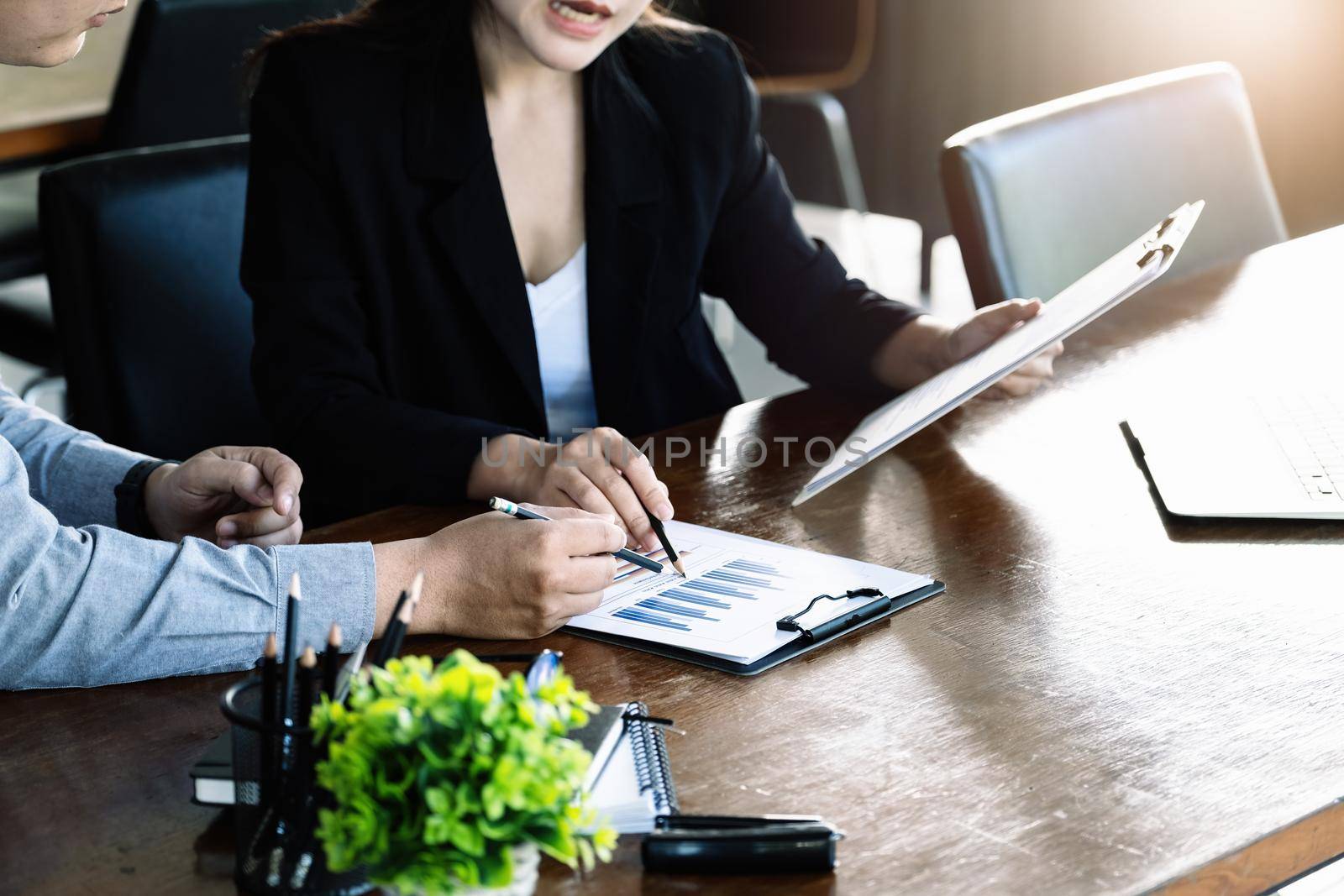 Teamwork concept, consultation, male economist holding pen pointing to budget, finance and investment documents, discussing and planning finances with female advisors in conference room. by Manastrong