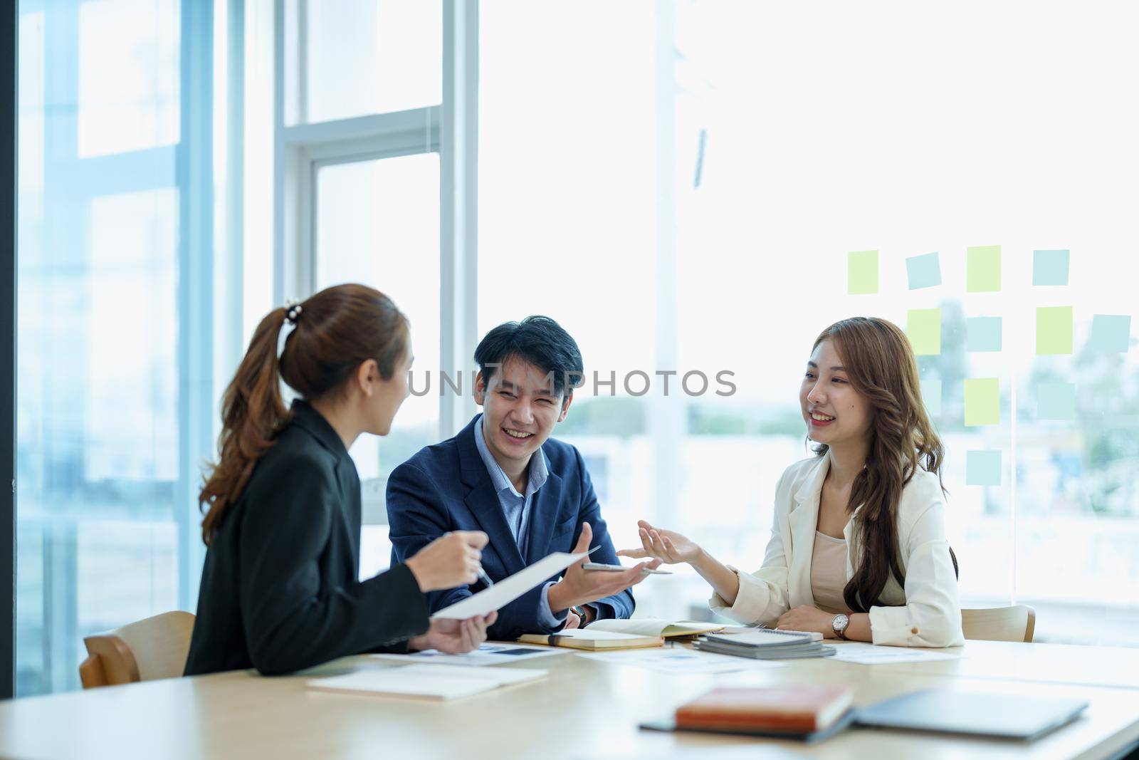 Happy group of business asian work cooperate with diverse team at office briefing, focused biracial businessman head meeting, collaborate discuss business ideas with colleagues at meeting.