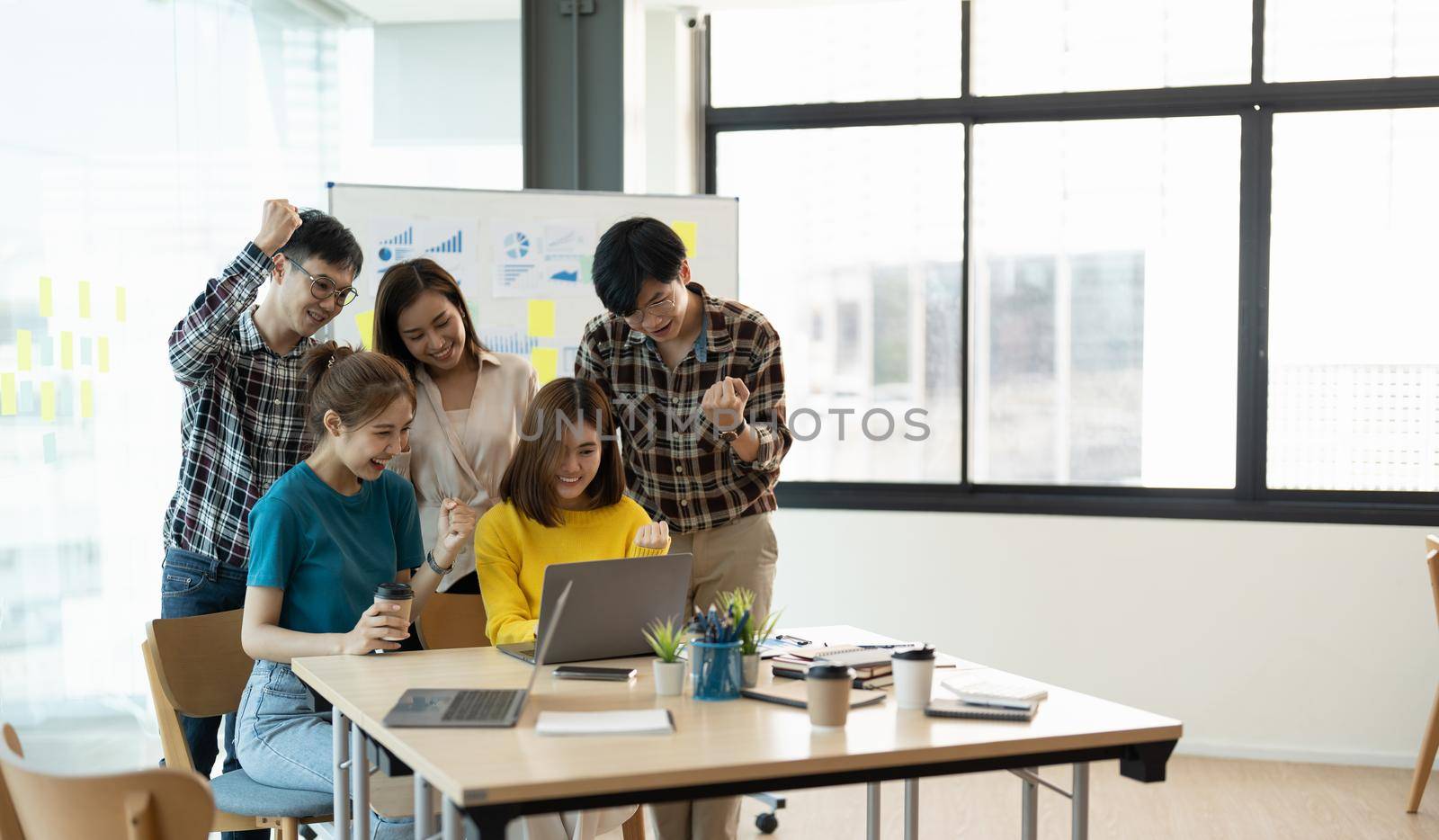 Young Asian Business Team Success Achievement Arm Raised, Teamwork cooperation, team building, or success business project concept.