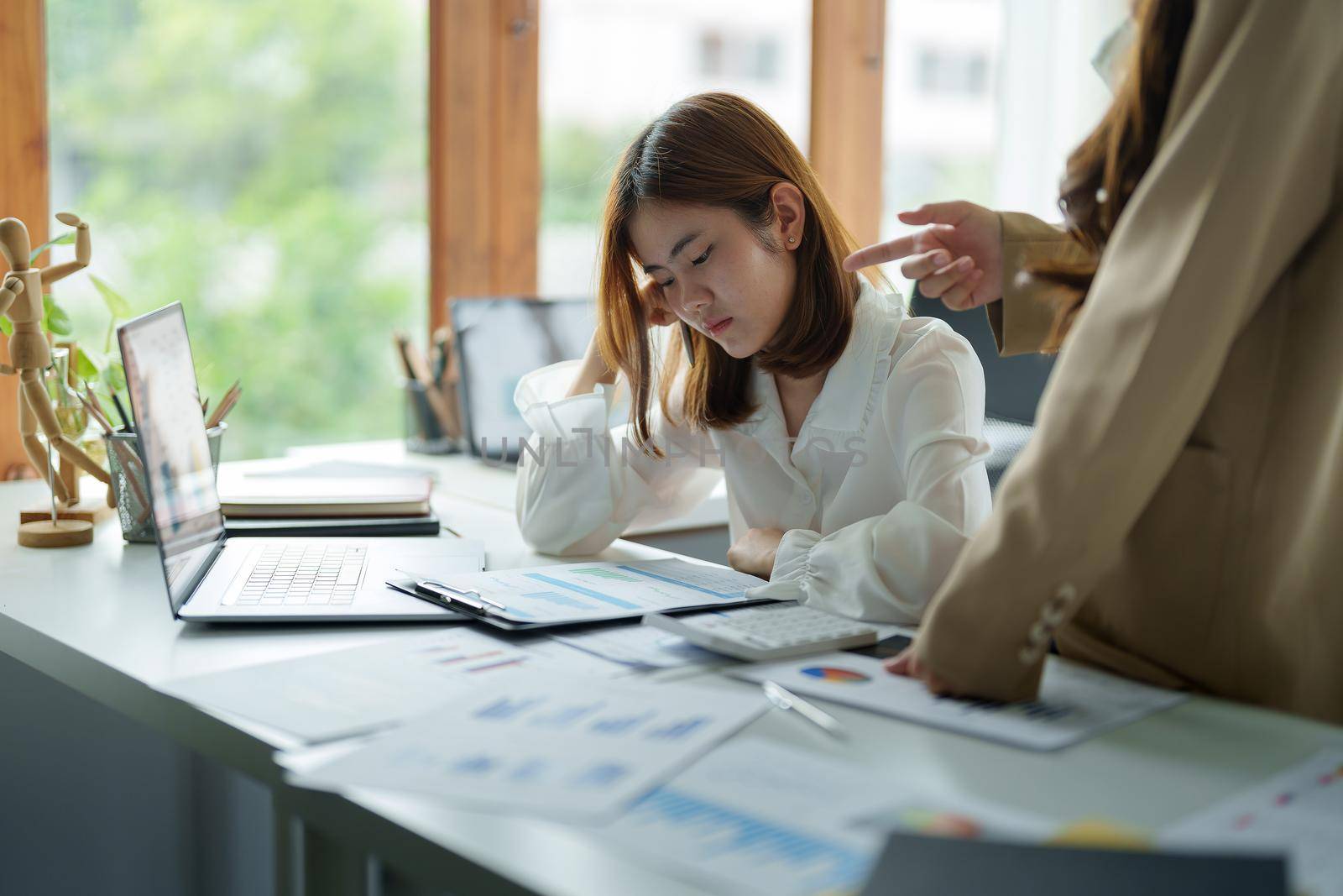 Young business woman feeling be serious, holding her head while her boss is complaining about the work