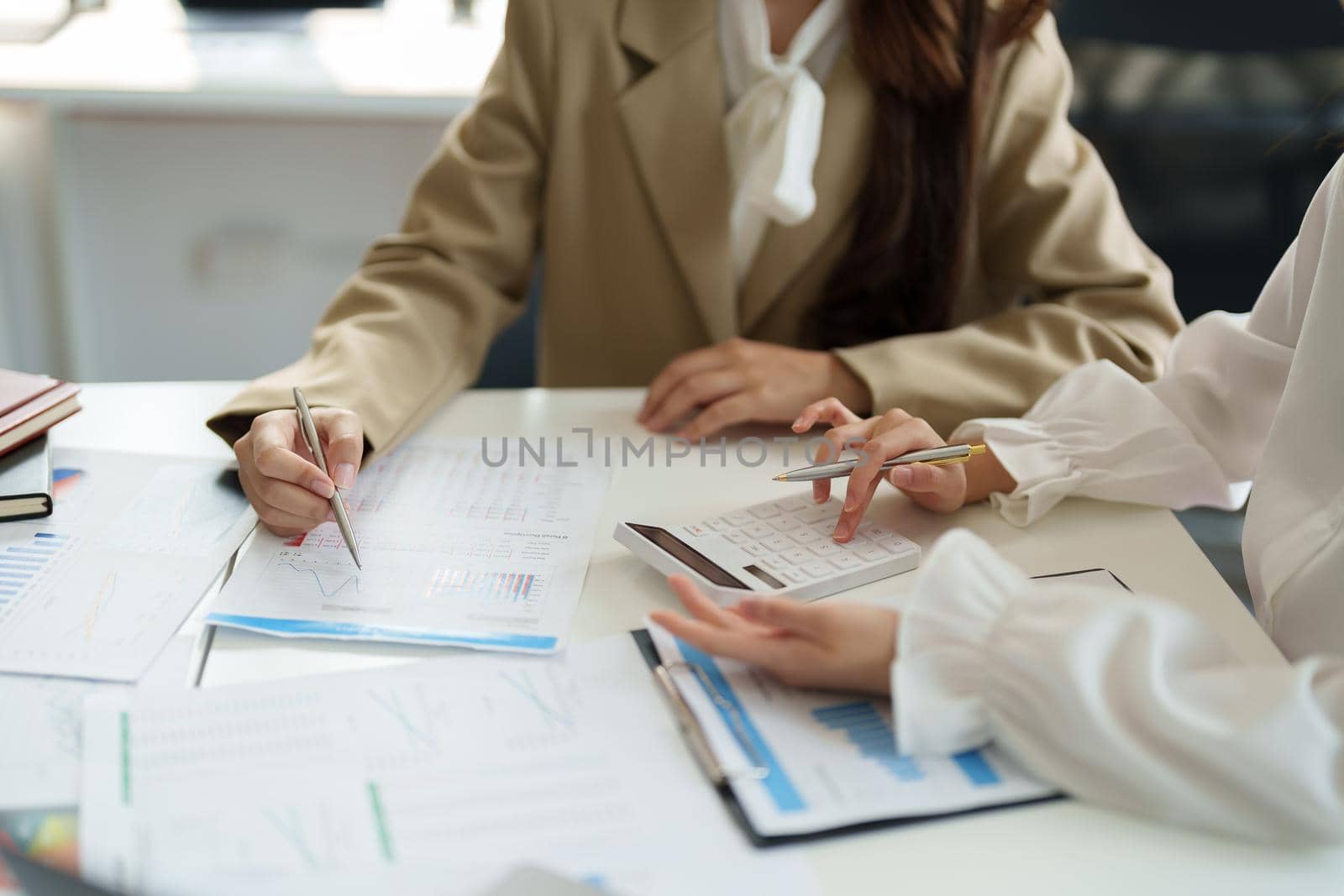 Two asian business woman and partner using calculator and laptop for calaulating finance, tax, accounting, statistics and analytic research concept.