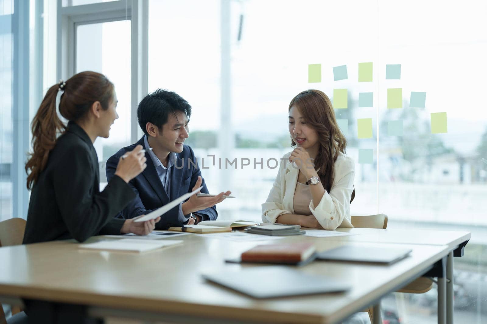 Asian business workgroup designers team with asian woman leader discuss paperwork financial report statistical data, forecasting working on common project. Brainstorm, briefing activity concept.