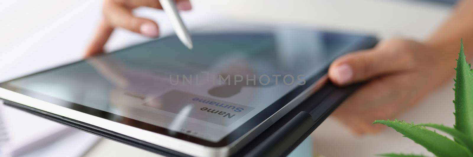 Close-up of person using tablet to perform work in office, modern device help with tasks. Create profile on website with pen, internet connection. Technology, business, career concept