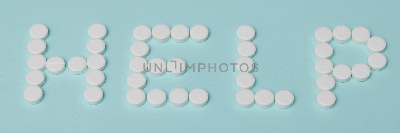 Close-up of drug prescription for treatment, pharmaceutical medicament, oral tablets. Inscription help made of round shaped tablets. Medicine, healthcare, recovery, addiction concept