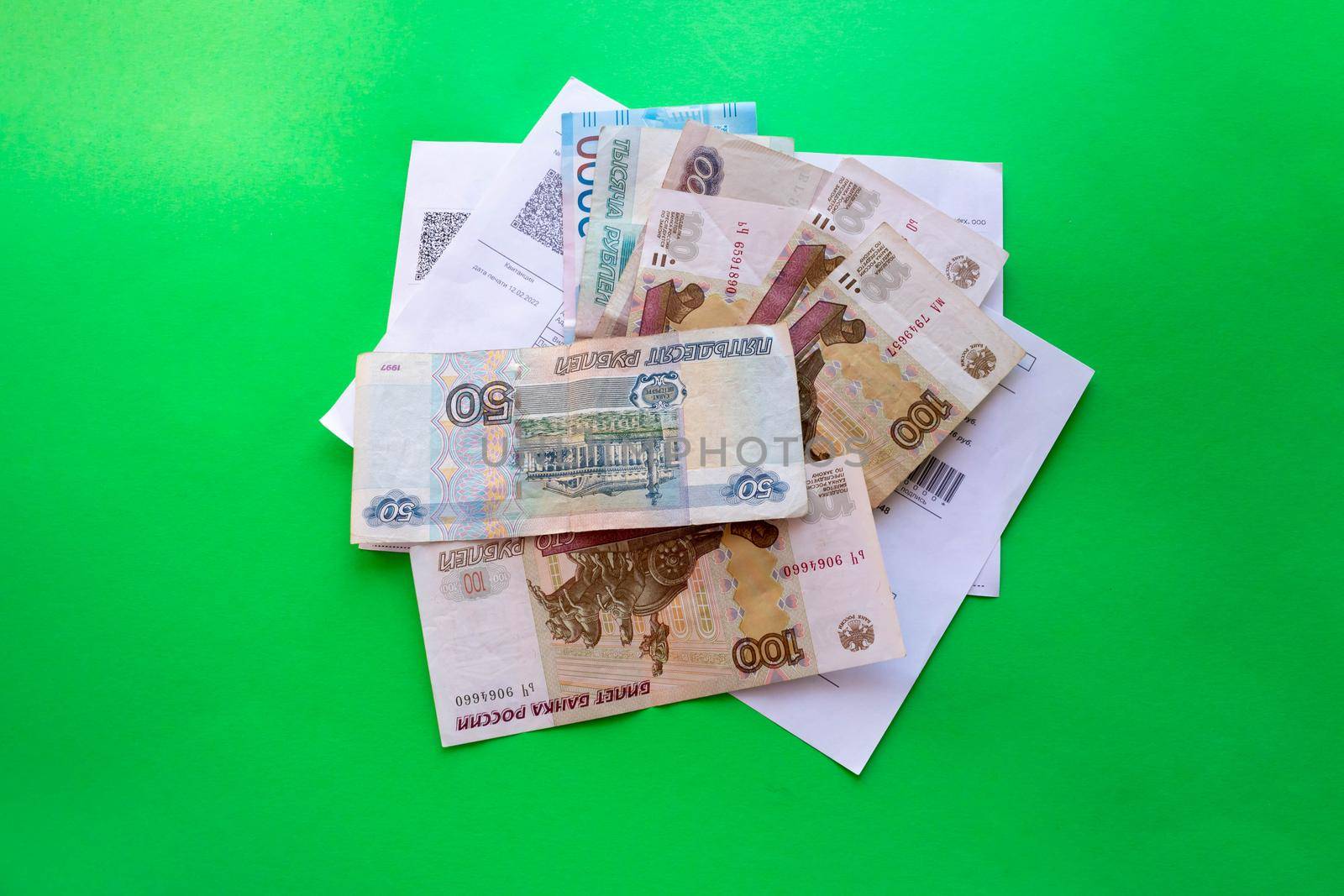 There is a stack of Russian banknotes on the receipts. A bundle of Russian money on a green background.