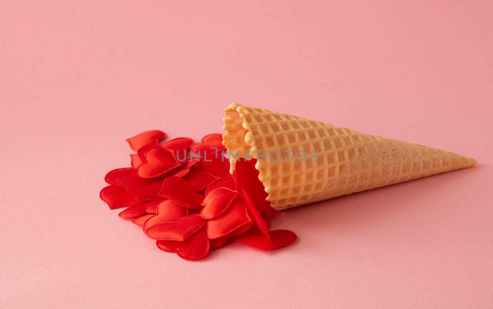 Abstract pink background. Red hearts in a waffle cone. The concept of love, a greeting card for Valentine's Day and Easter.