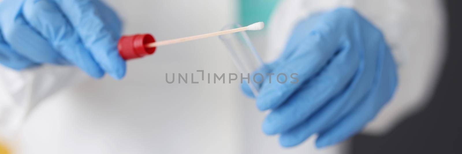 Close-up of doctor in protective suit medical mask gloves holding swab saliva sample for diagnostic, coronavirus virus in lab. Coronavirus, testing, medicine, healthcare concept