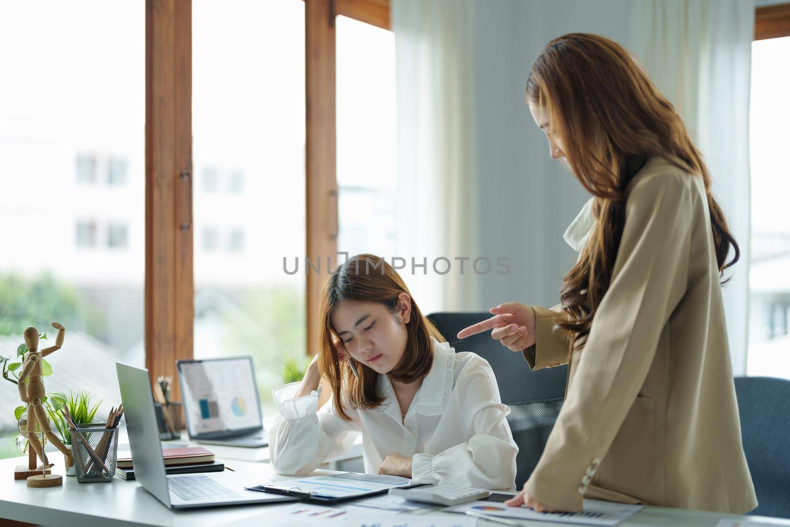 Young business woman feeling be serious, holding her head while her boss is complaining about the work