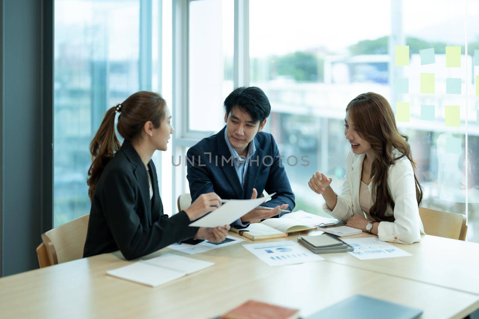 Happy group of business asian work cooperate with diverse team at office briefing, focused biracial businessman head meeting, collaborate discuss business ideas with colleagues at meeting.