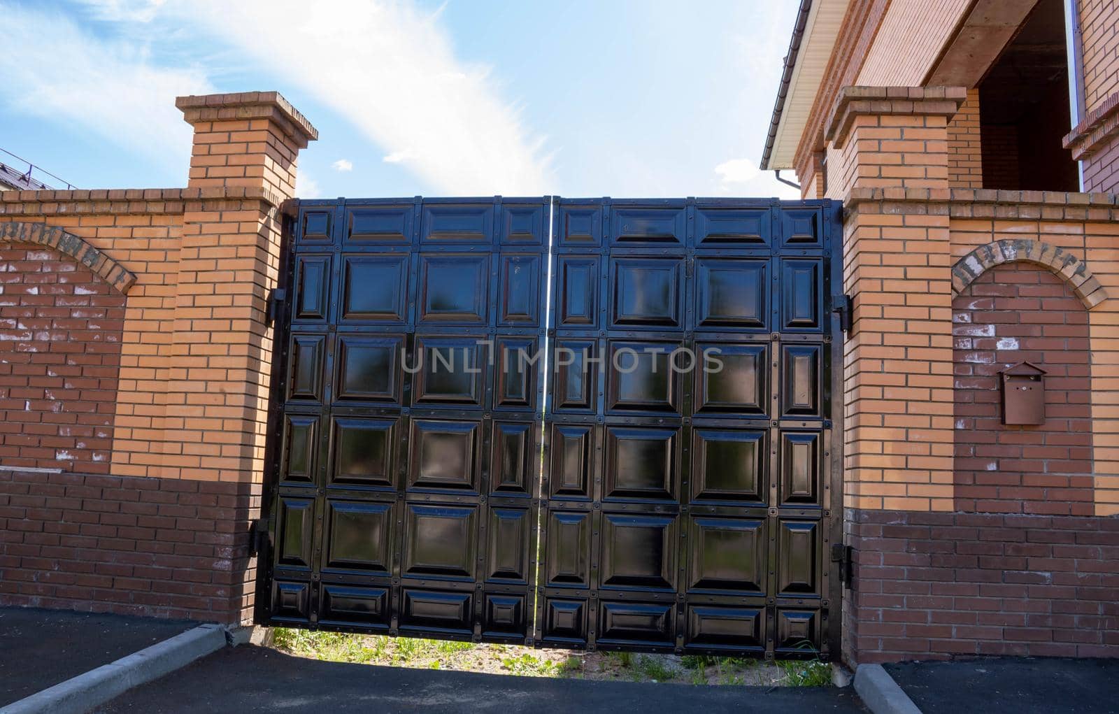 New forged metal double gates for entry of cars into the yard closed.