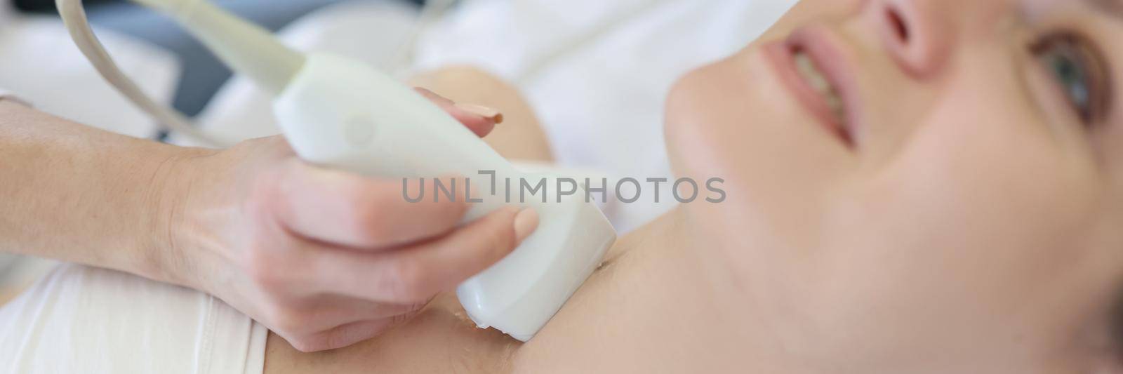 Portrait of ultrasound scanning diagnostic for young woman of thyroid gland in clinic, doctor runs ultrasound sensor over patients neck. Diagnostics, healthcare, checkup concept