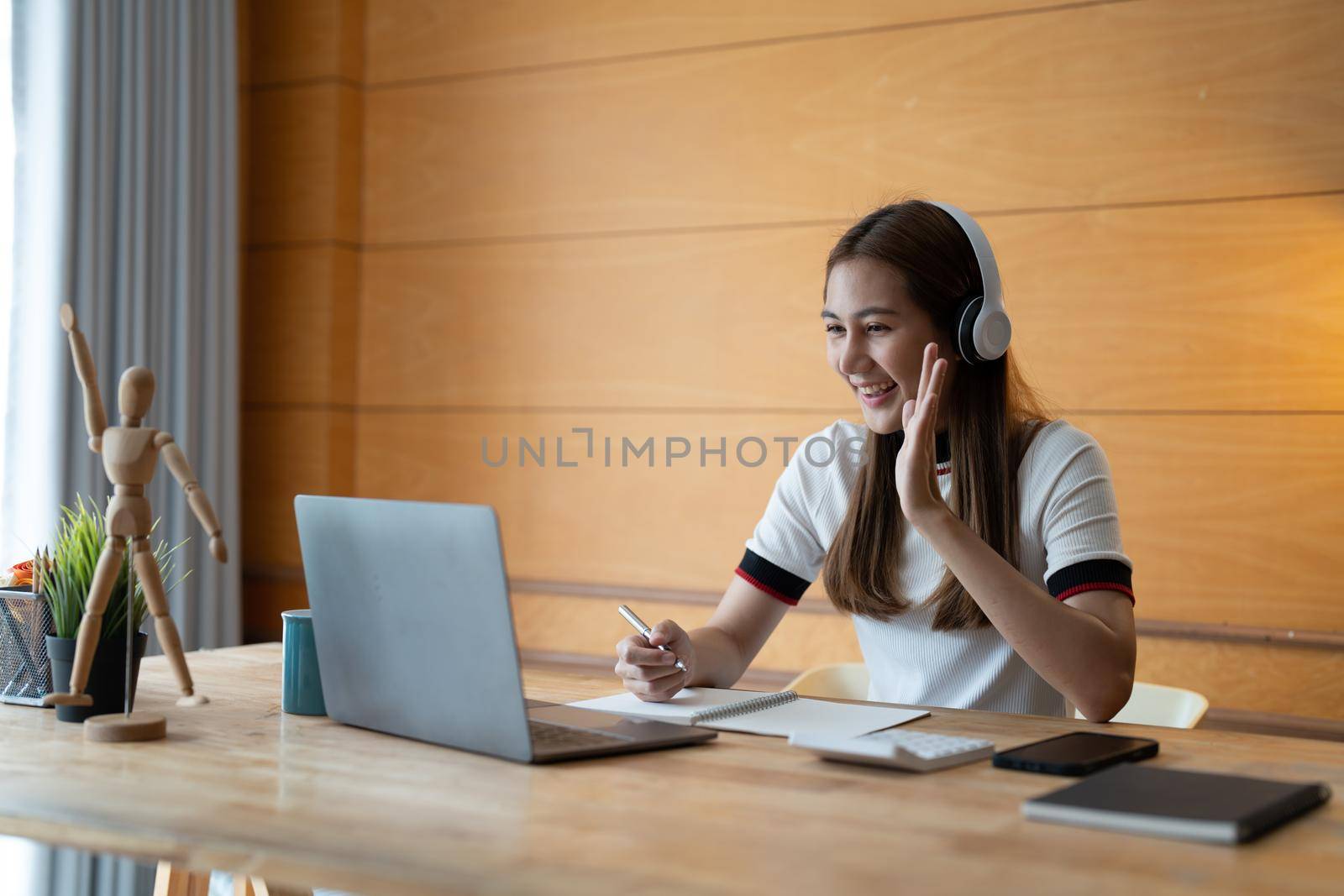 Smiling girl student wear taking note for study online with teacher, happy young woman learn language listen lecture watch webinar write notes look at laptop at home, distant education.