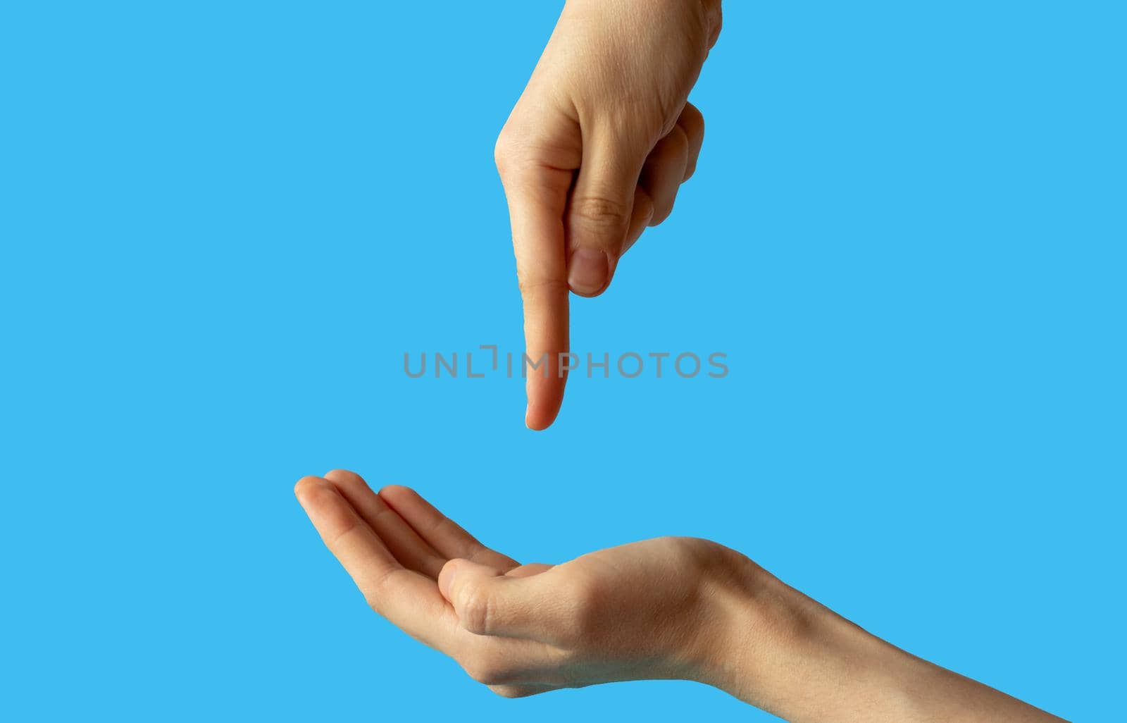 Close-up of women's hands, side view with the palm up, and the second hand points a finger at the palm. isolated on a blue background by lapushka62