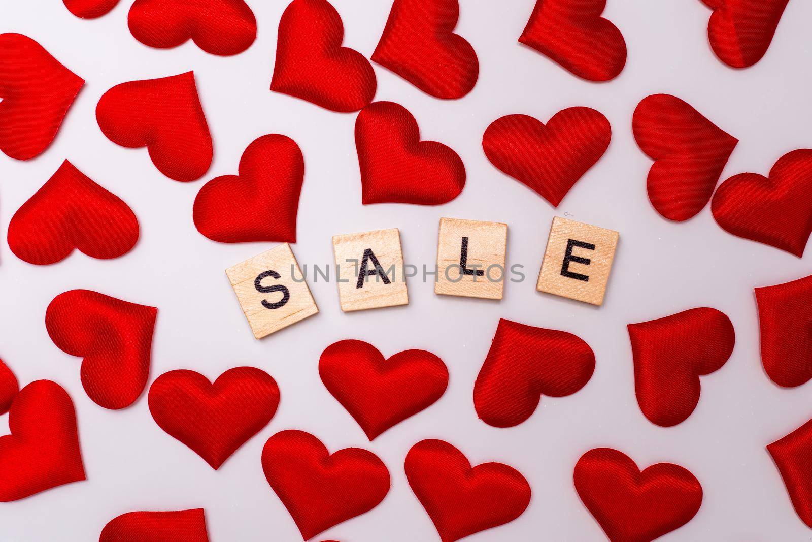 Sale inscription, a lot of red hearts on a white background