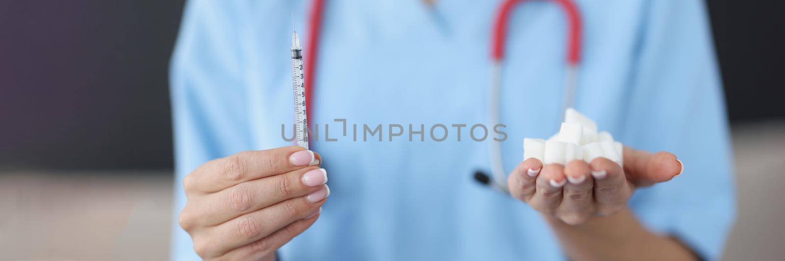 Close-up of doctor hands holding dose of insulin in syringe and loaf-sugar in hands. Medicine and treatment for diabetes. Diabetes Day, support and care concept