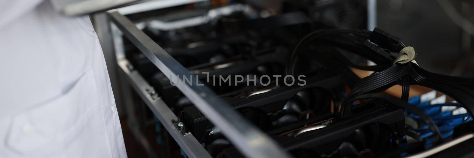 Close-up of technician miner with laptop research mining farm work. Equipment for mining cryptocurrency. Station for extraction of digital cryptocurrencies such as bitcoin, ethereum or altcoins